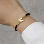 Pulsera Premium de Cuerda Negra y Letras Doradas – Joyería Minimalista de Alta Calidad